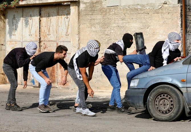 Palestinian demonstrators take cover during clashes with Israeli soldiers in the occupied West Bank on Friday. Jordan warned Friday that military escalation by Israel against Palestinians threatens to trigger a new wave of violence where everyone will pay. (AFP)