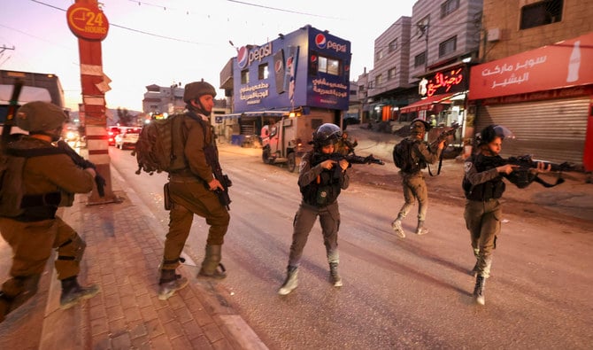 Israeli security forces aim their guns as they deploy in the occupied West Bank city of Hawara on December 2, 2022. (AFP/File)