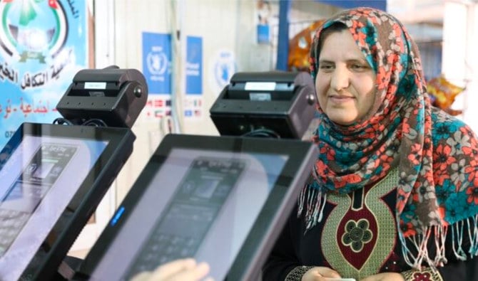 Hamda, a Syrian refugee from Daraa, looks into the iris scan camera at a grocery store in Jordan. (WFP)