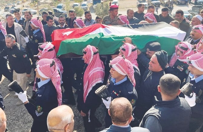 Jordanian security personnel in Jerash carry the coffin of the senior police officer who was killed in Thursday’s riots. (Reuters)
