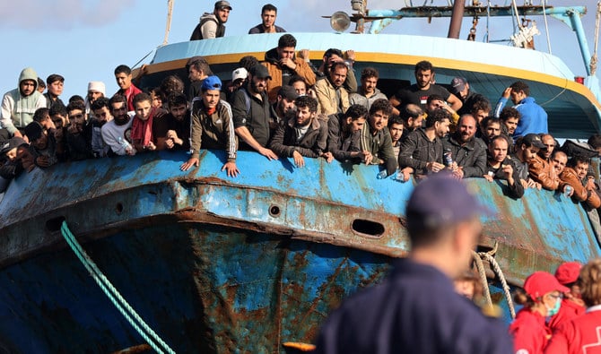 Rescued refugees and migrants stand aboard a boat at the town of Paleochora, southwestern Crete island on November 22, 2022, following a rescue operation. (AFP/File)