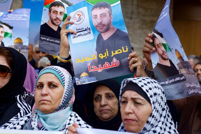 People protest following the death of Palestinian militant Nasser Abu Hmaid who was jailed by Israel and died in Israeli hospital after his health conditions deteriorated. (Reuters)