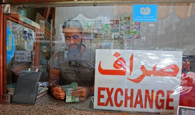 A money changer counts notes at his shop in the Lebanese capital Beirut on September 22, 2022. (AFP/File)