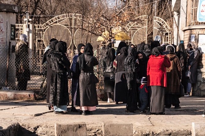 Female students stand outside a university in Kabul after Taliban security prevented them from entering on Wednesday. (AFP)