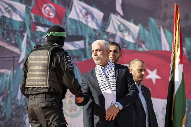 Yahia Al-Sinwar (C), Gaza Strip chief of Hamas, shakes hands with a fighter of Hamas’ Qassam Brigades during a rally marking the 35th anniversary of the group’s foundation, in Gaza City on December 14, 2022. (AFP)