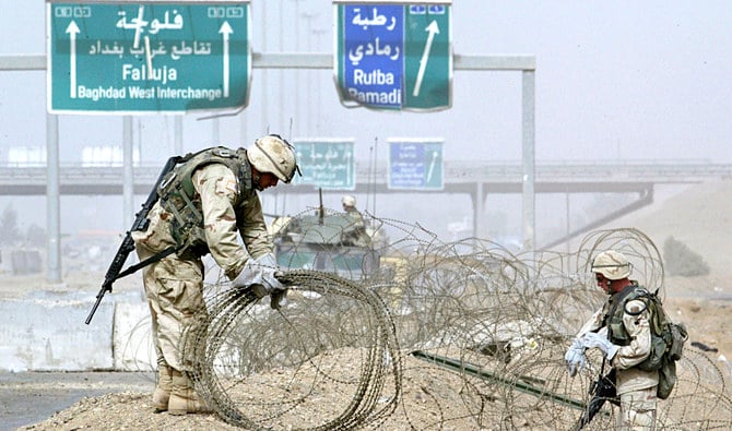 US Army troops clear rolls of razor wire from the main entrance to Fallujah, Iraq on April 30, 2004. (AFP file photo)