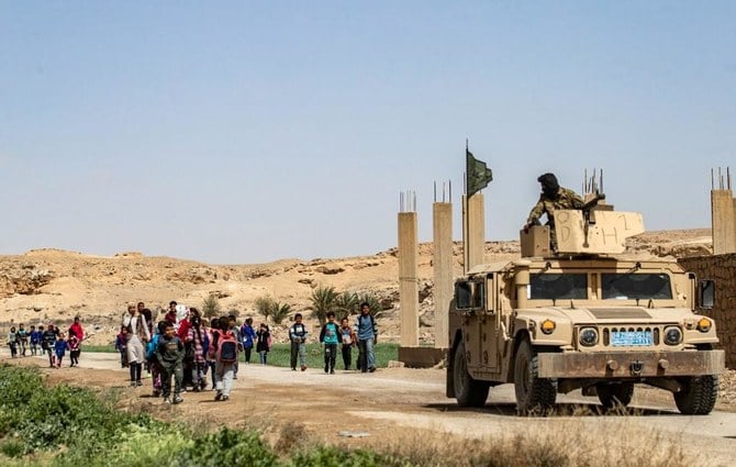 Above, fighters of the Kurdish-led Syrian Democratic Forces stand guard in Baghouz in Syria’s northern Deir Ezzor province on March 24, 2021. (AFP)