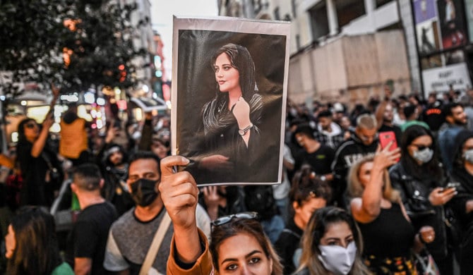 A protester holds a portrait of Mahsa Amini during a demonstration in Istanbul on September 20, 2022. (AFP)