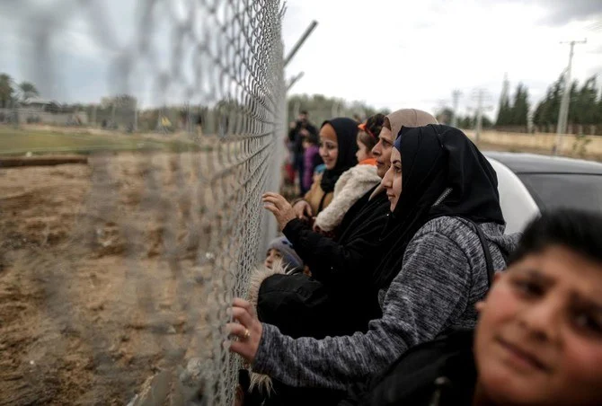 Palestinian women watch the football match between Al-Nuseirat and Al-Jalaa standing outside the fence of the stadium south of Gaza City, in January 2018. (AFP/File)