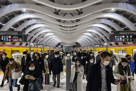 People disembark from a train at Shibuya station in Tokyo on December 21, 2022. (AFP)