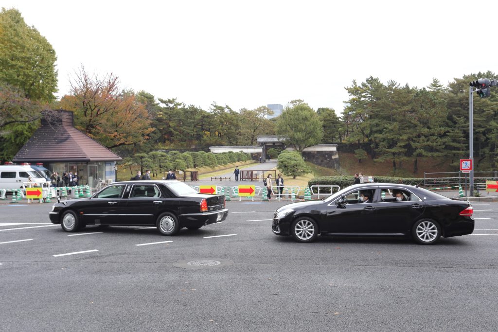 The Emperor acknowledged people waiting to greet him at the gates of the palace on his return. (ANJ)