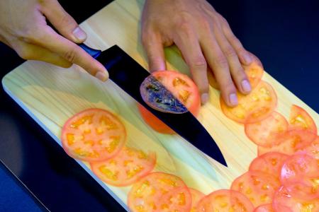 This picture taken on September 2, 2022, shows a demonstration to test the sharpness of a knife with a tomato at a factory of Sumikama Cutlery in Seki, Gifu prefecture. (AFP)