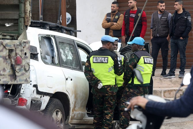 Members of the UN peacekeepers forces gather near a bullet-riddled car at the site where a UN peacekeeping force UNIFIL convoy came under small arms fire, in the village of al-Aqbiya in south Lebanon (AFP)
