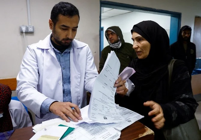 A doctor looks through the medical file of a woman patient, Nalat Zeino, at Shifa hospital in Gaza City on Thursday. (Reuters)