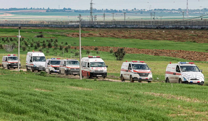 A convoy of Palestinian ambulance vehicles moves along the border fence between Israel and the Gaza Strip east of Gaza City on January 9, 2023, during a protest against Israel's prevention of allowing diagnositc medical equipment to enter hospitals in the Palestinian enclave. (AFP)