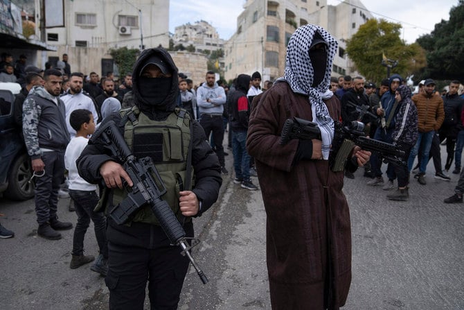 Two Palestinian gunmen take part in the funeral of Ahmed Abu Junaid, 21 in the West Bank refugee camp of Balata, Nablus, on Jan. 12, 2023. (AP)