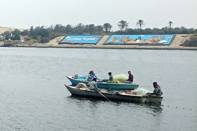 Fishermen in boats sail across the Suez Canal near Ismailia, eastern Egypt, on January 9, 2023. (AFP)