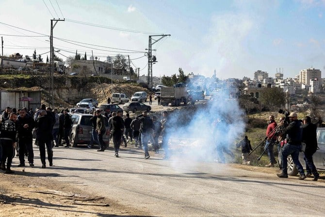 Tear gas is fired by Israeli forces to disperse people and journalists gathering at the scene near the body of Palestinian Hamdi Abu Dayyeh in Halhul village, north of the city of Hebron in the occupied West Bank. (AFP)