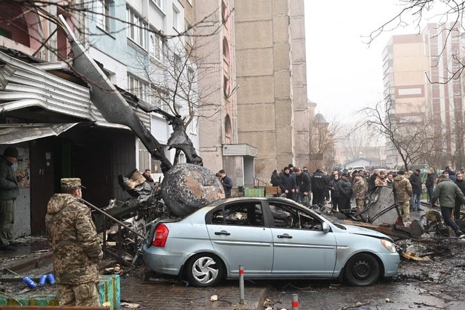 Military and onlookers stand at the site where a helicopter crashed near a kindergarten outside the capital Kyiv, killing 18 people, including two children and Ukrainian interior minister (AFP)