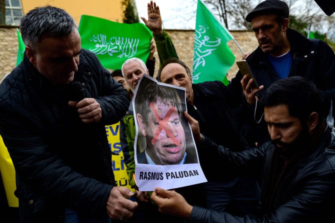 Protesters burn a portrait of Rasmus Paludan in front of the Consulate General of Sweden in Istanbul, Turkey, on January 22, 2023, after the rightwing extremist burned a copy of the Qur'an near the Turkish Embassy in Stockholm. (AFP) 