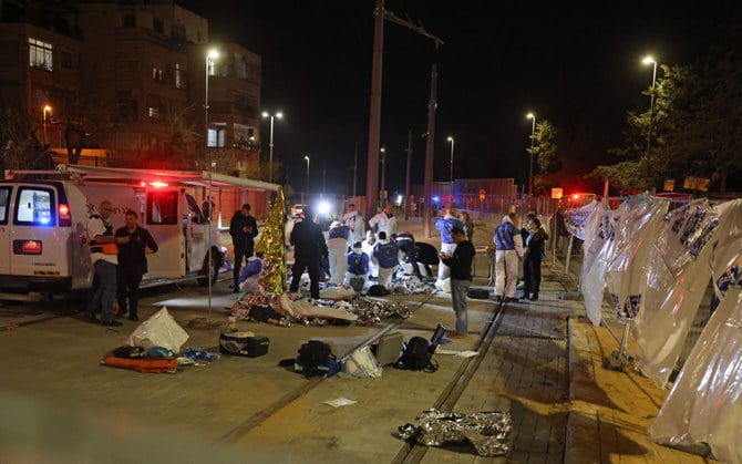 Israeli emergency personnel help victims at the site of a gun attack in a settler neighborhood in Israeli-annexed East Jerusalem on Jan. 27, 2023. (AFP)