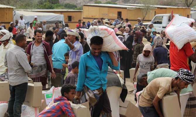 Internally displaced people collect food aid distributed by a charity in Taiz, Yemen. (Reuters/File)