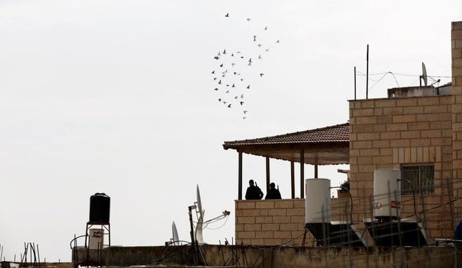 Israeli border police officers stand on the balcony of the family home of gunman Khaire Alkam as it is sealed off, A-Tur, East Jerusalem, Jan. 29, 2023. (Reuters)