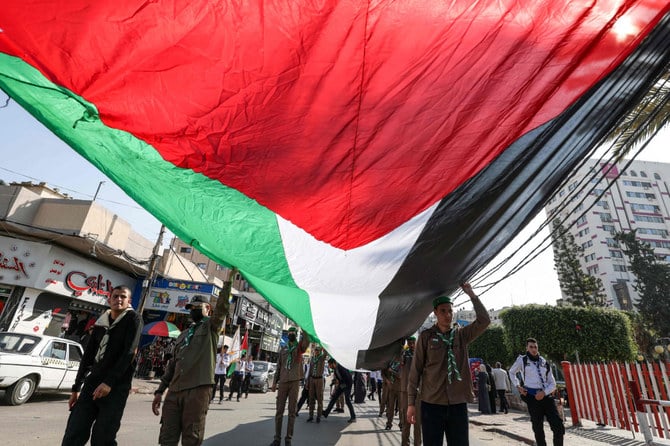 Palestinian Scouts carry a giant national flag as they march in support fellow Palestinians in Jerusalem, in Gaza City. (AFP)
