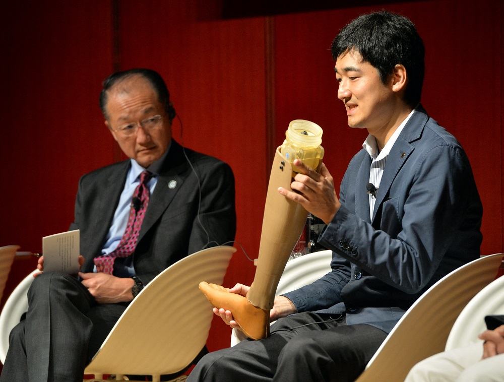 World Bank Group President Jim Yong Kim (left) watches an artificial leg as Ken Endo (right), CEO of Xiborg displays his product at a symposium in Tokyo on July 10, 2014. (AFP)