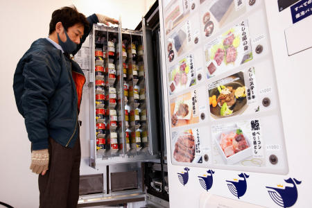 An employee displays the canned whale meat inside one of the machines of a vending machine shop, opened by a Japanese whale-hunting company, in Yokohama, Japan, January 24, 2023. (Reuters)
