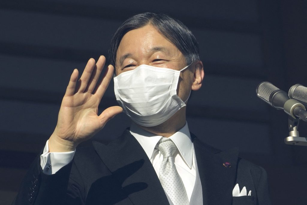 Japan's Emperor Naruhito waves to well-wishers from a bullet-proof balcony during a public appearance with the Japanese royal family at the Imperial Palace in Tokyo on January 2, 2023. (AFP)