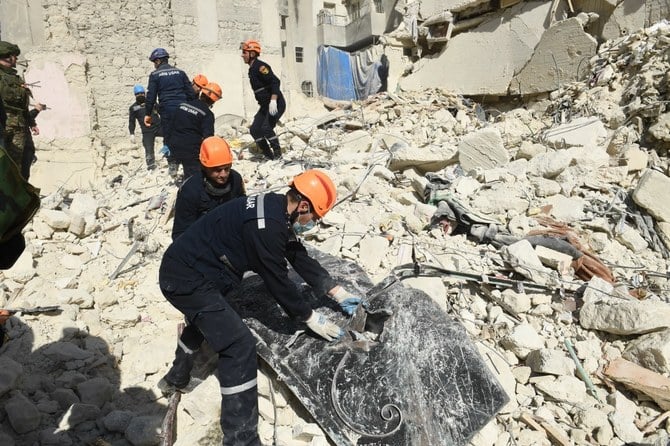 Armenian rescuers sift through the rubble of a collapsed building in the city of Aleppo. Feb. 09, 2023 (File/AFP)