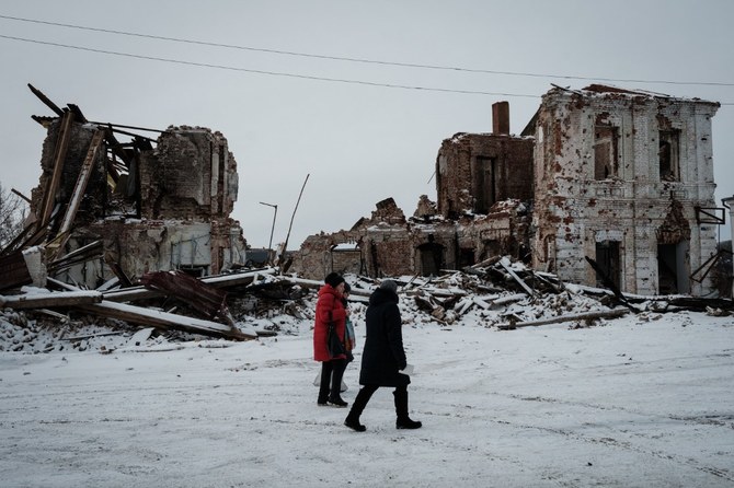 People walk past destroyed buildings in Kharkiv. Feb 24. marks the one-year anniversary of the Russia-Ukraine war (File/AFP)