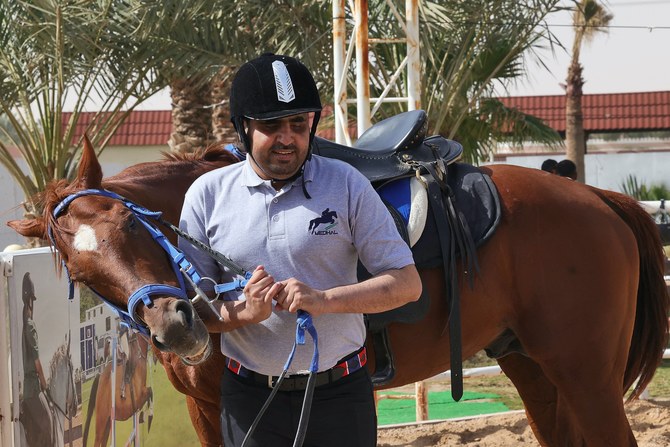 Saudi blind jockey Badr Al-Sharari leads a horse during a training session at Medhal equestrian centre in eastern Riyadh. AFP