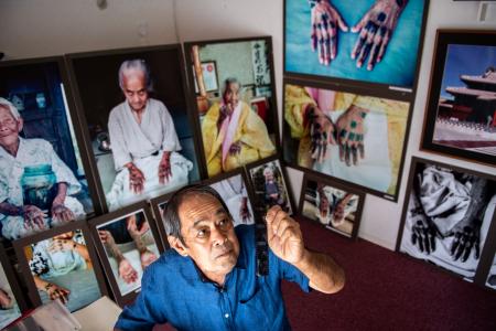 This picture taken on August 23, 2022 shows veteran photographer Hiroaki Yamashiro checking archived negative and transparency films at his studio during an interview with AFP in Naha, Okinawa prefecture. (AFP)