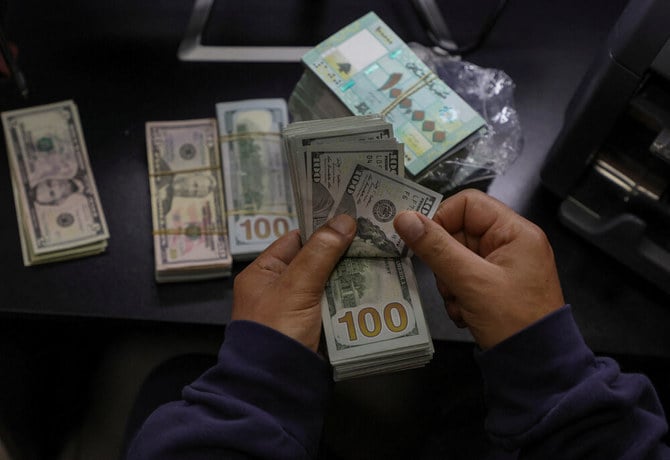 A money exchange vendor counts US dollar banknotes at his shop in Beirut, Lebanon January 19, 2023. (Reuters/File)