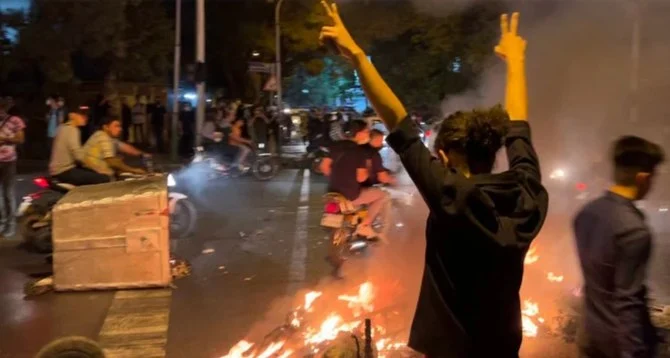 A demonstrator raising his arms and makes the victory sign during a protest for Mahsa Amini in Tehran on September 19, 2022. (AFP/File)