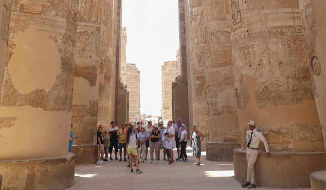 Tourists visit the Karnak Temple on Friday, Nov. 26, 2021, After one day the reopening ceremony of the Avenue of Sphinxes commonly known as El Kebbash Road in Luxor, Egypt. (AP)