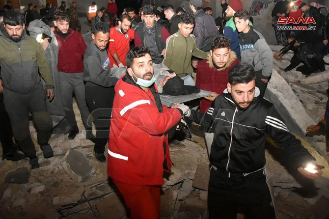 Rescuers evacuate a victim from an 8-story building that collapsed in Hama, Syria after an 7.8-magnitude earthquake in southern Turkiye on Feb. 6, 2023. (SANA handout via AFP)