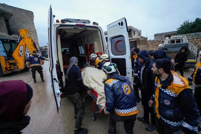 Members of the Syrian civil defence, known as the White Helmets transport a casualty pulled from the rubble into an ambulance, following an earthquake in Shalakh village in Idlib's eastern countryside, early on February 6, 2023. (AFP)