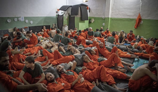 Men, suspected of being affiliated with the Daesh group, gather in a prison cell in the northeastern Syrian city of Hasakeh on October 26, 2019. (AFP)