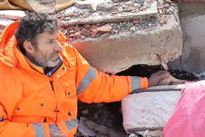 Mesut Hancer holds the hand of his 15-year-old daughter Irmak, who died in the earthquake in Kahramanmaras. (AFP)