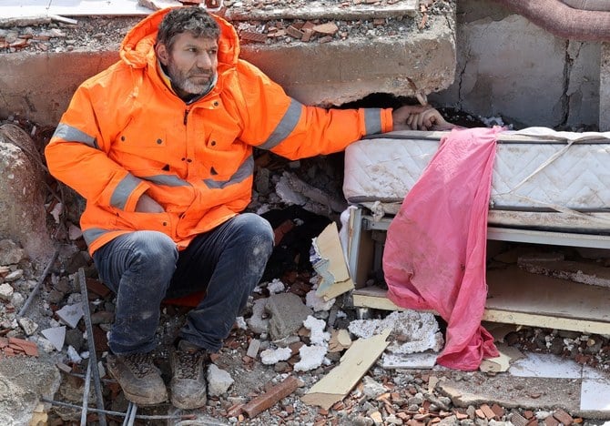 Mesut Hancer holds the hand of his 15-year-old daughter Irmak, who died in the earthquake in Kahramanmaras. (AFP)