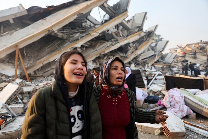 Women react near rubble following an earthquake in Hatay, Turkiye, February 7, 2023. (Reuters)
