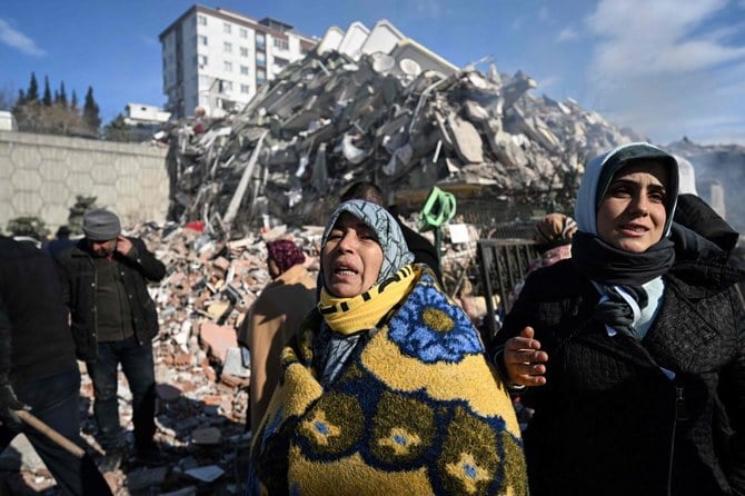Women react as they wait for a rescue team next to their collapsed building in the southeastern Turkish city of Kahramanmaras, on February 8, 2023. (AFP)