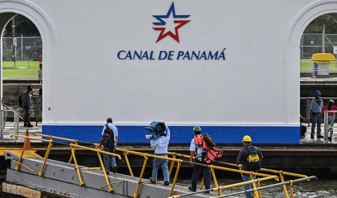 Workers of Panama Canal walk over the gates of Miraflores locks in Panama City on December 15, 2022. (AFP/File)
