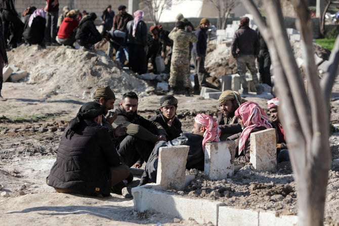 A man walks in a grave of earthquake victims in the town of Jandaris, in Syria's rebel-held part of Aleppo province, on Feb.9, 2023. (Bakr Alkasem / AFP)