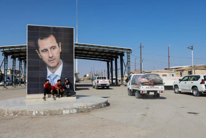 A picture of Syrian President Bashar al-Assad is seen on a road where vehicles containing aid from Hashid Shaabi head to Syria to support victims of the deadly earthquake. (Reuters)
