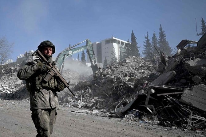 A Turkish soldier patrols next to collapsed buildings in Kahramanmaras on February 13, 2023, as rescue teams continue to search for victims and survivors, after a 7.8 magnitude earthquake struck the border region of Turkiye and Syria. (AFP)
