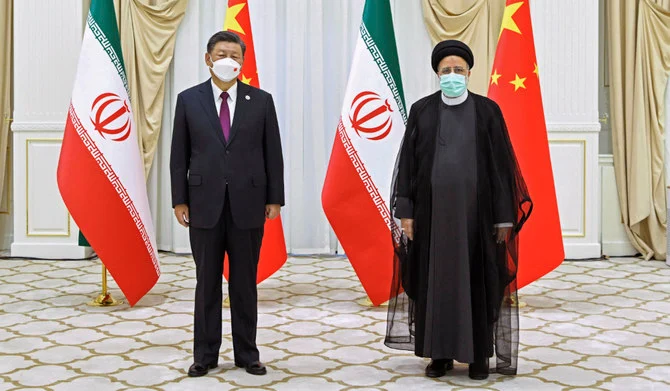 In this file photo released by China's Xinhua News Agency, Iran's President Ebrahim Raisi, right, and Chinese President Xi Jinping pose for a photo on the sidelines of a meeting at the Shanghai Cooperation Organization (SCO) summit in Samarkand, Uzbekistan on Sept. 16, 2022. (AP)